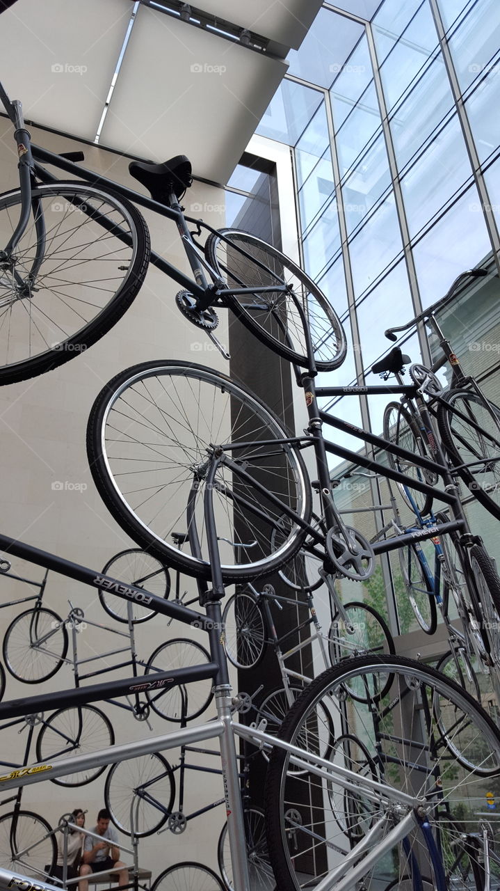 A bicycle sculpture rising up towards the city skyline.