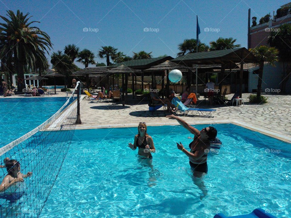 Woman playing volleyball in swimming pool