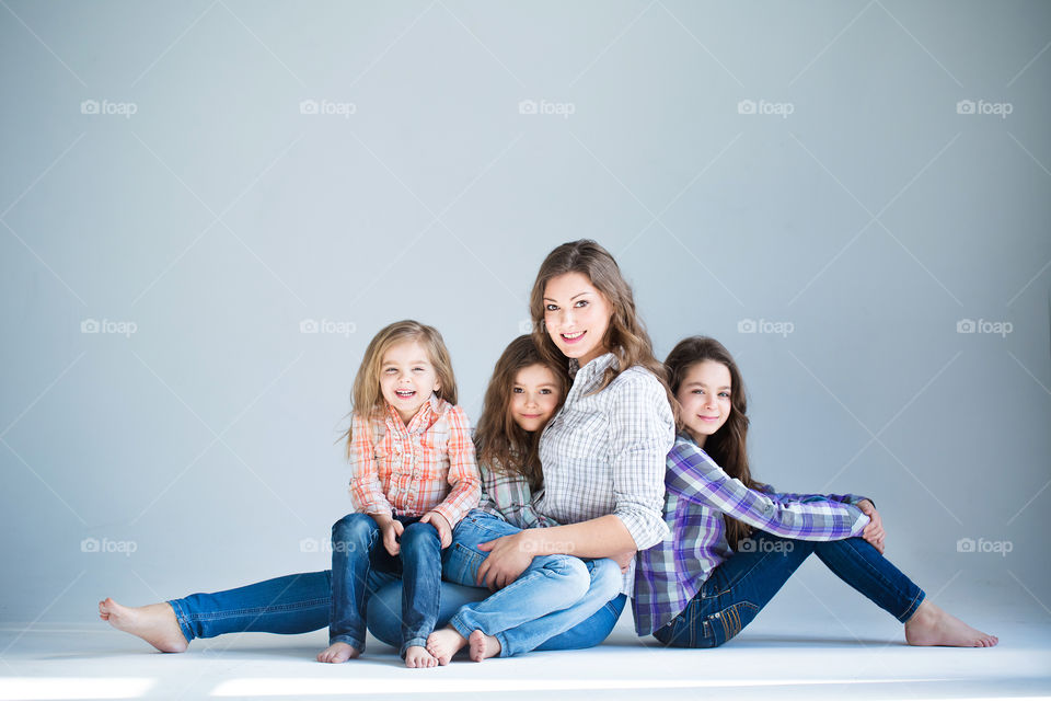 beautiful three sisters hug and laugh with mom