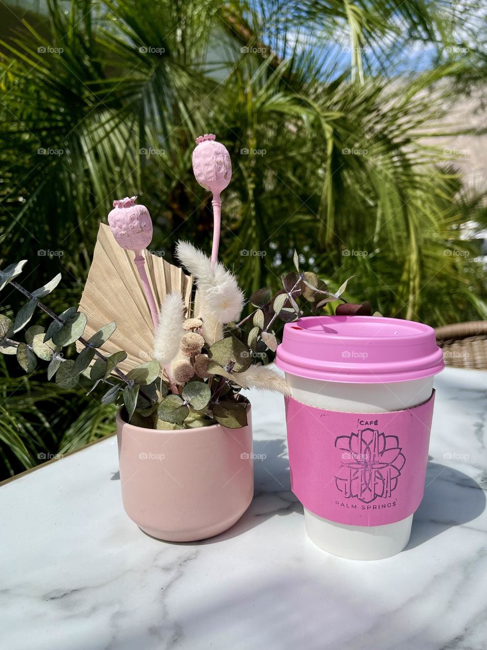 Pink Barbie coffee next to pink flowers 