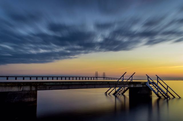 Bridge over sea at sunset