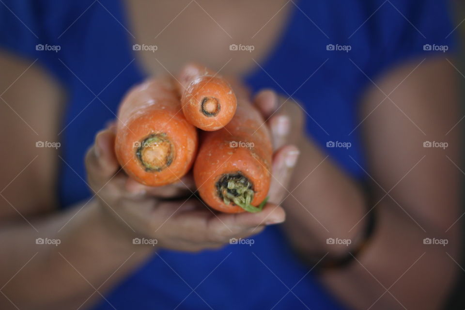 Mid section of girl holding carrots