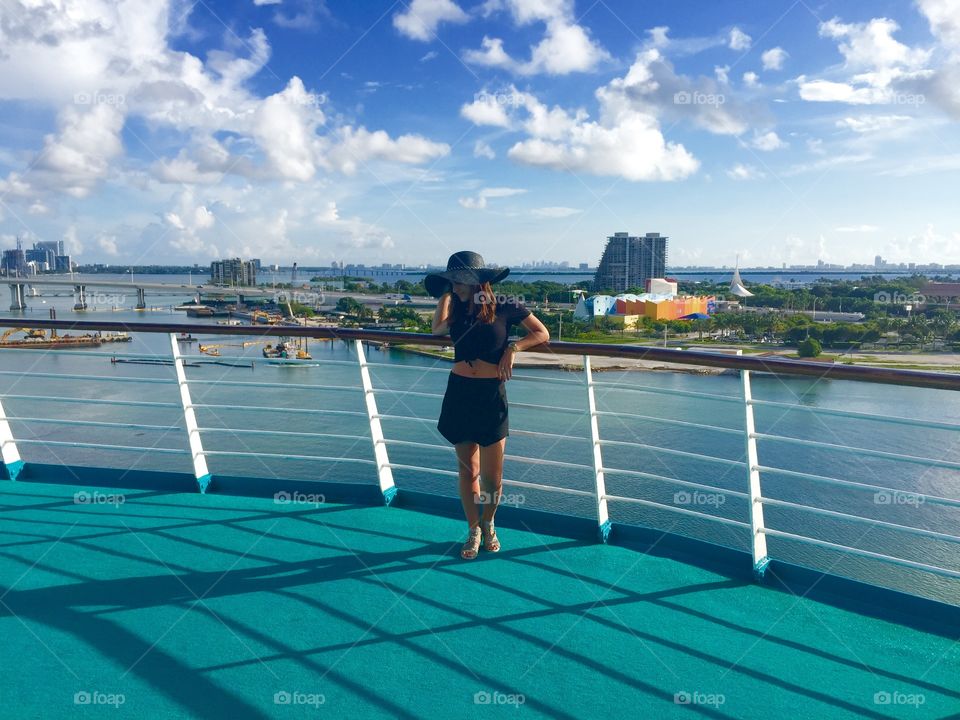 Young woman in ship against cloudy sky