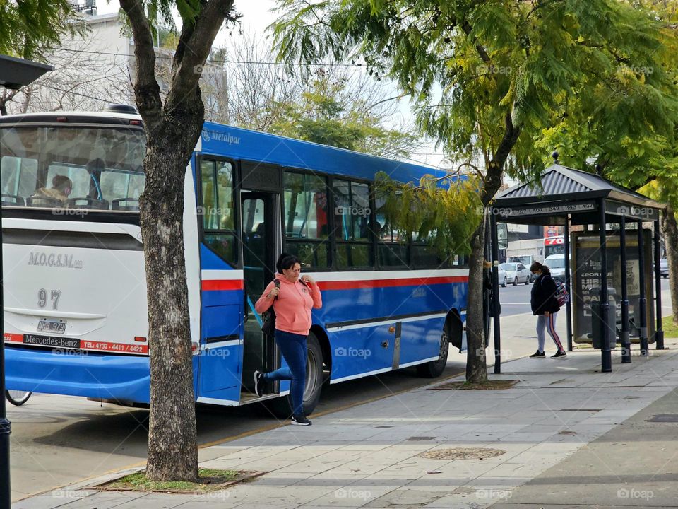 Choosing public transportation to come and go; passanger getting on and another getting off