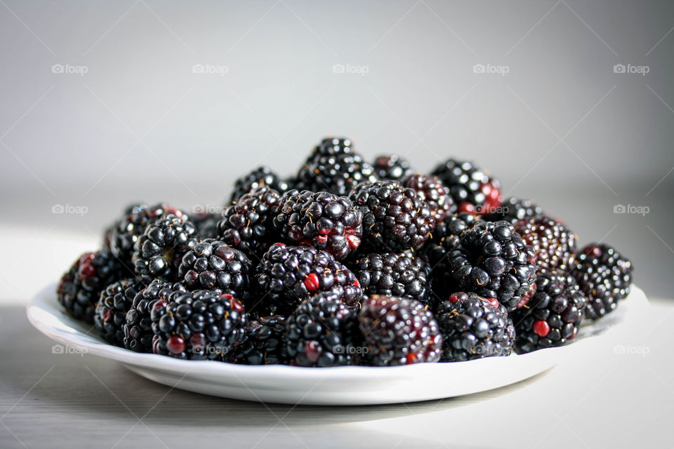 Plate with juicy ripe blackberries