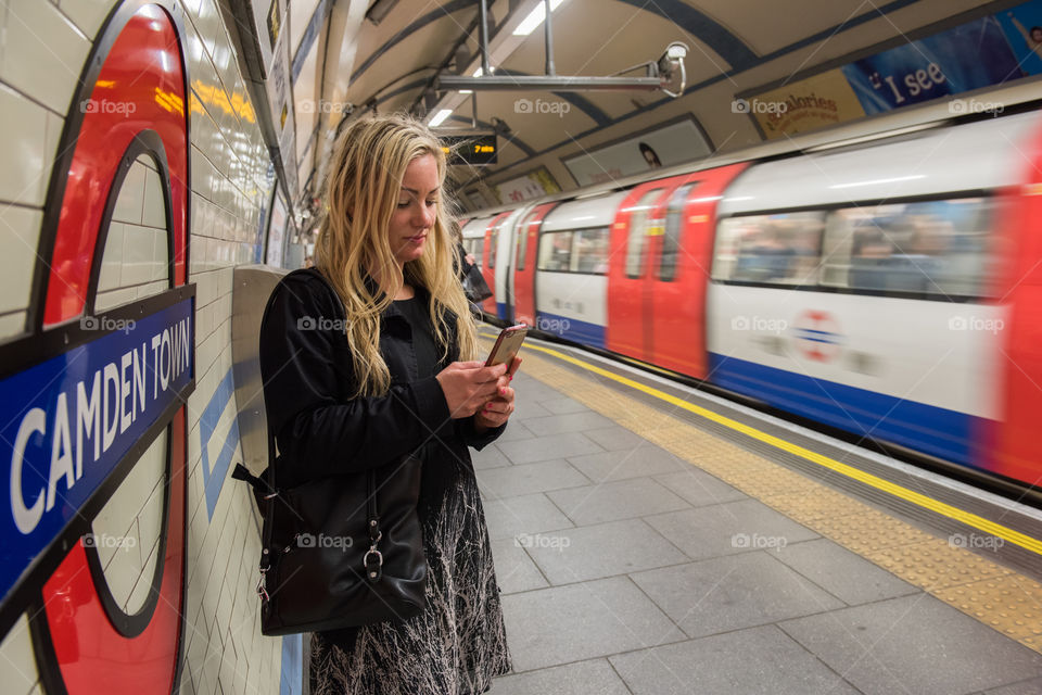 Woman swedish tourist in London 30 years plus looking on ger phone in London tube.
