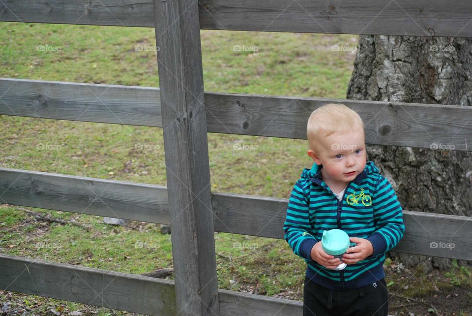 Toddler against wooden fence