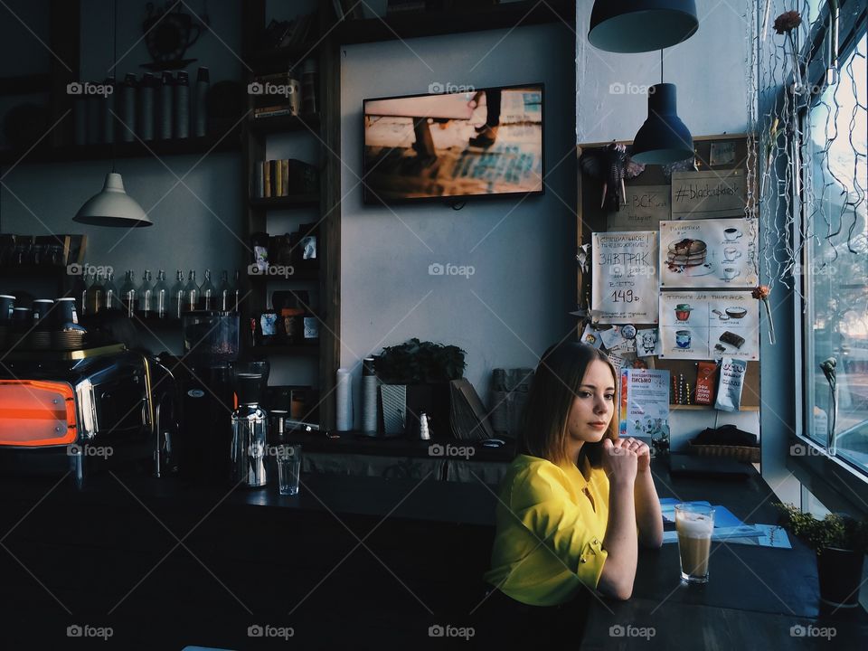 Pretty woman sitting in café with glass of coffee