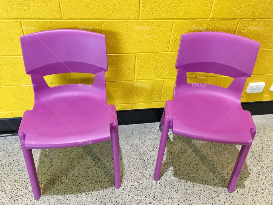 Pink chairs and yellow wall.