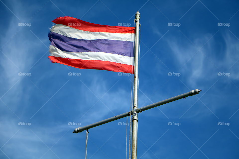 Thailand flag​ flutter​ on​ the blue sky.