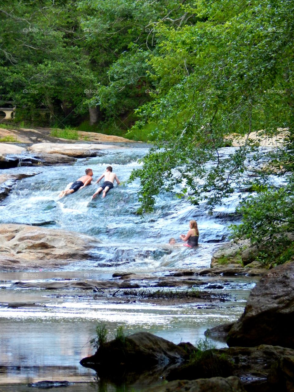 People cooling off at the creek rock slide in Victoria Bryant state park, Georgia