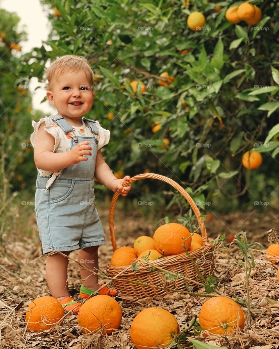 Smiling baby in the orange field 