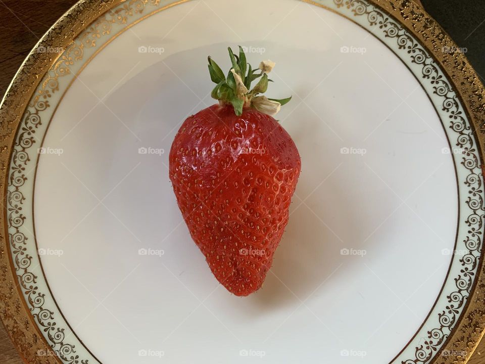 A  strawberry on a plate