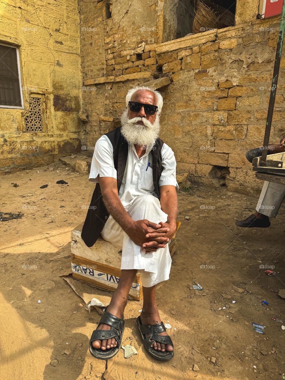 A savage old man sitting in full swag with sunglasses on in jaisalmer