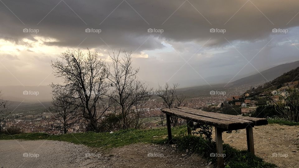 dark clouds and bench