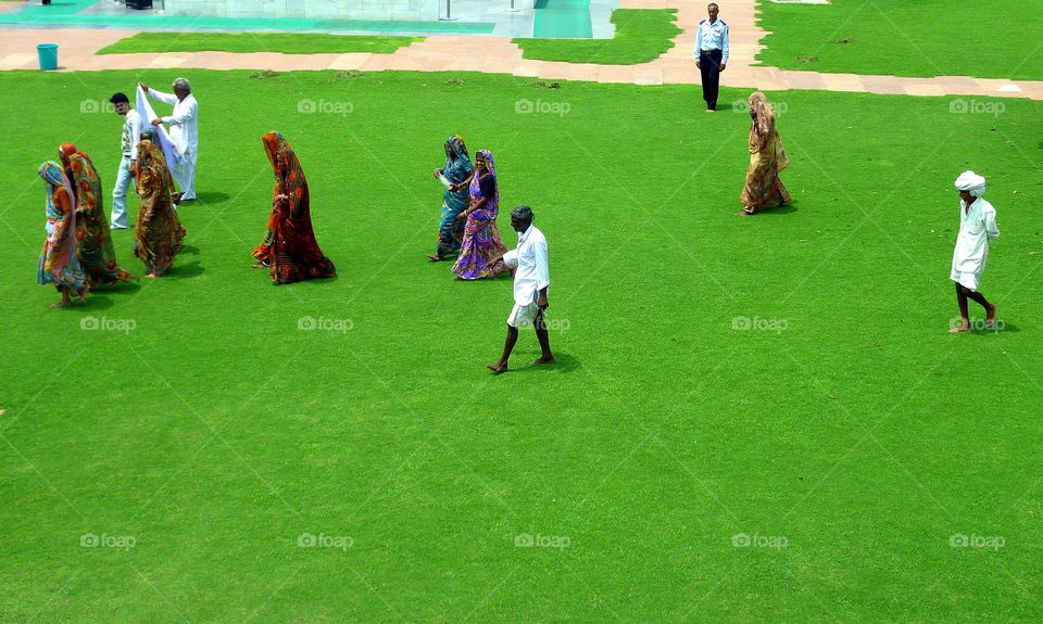 indian people walking on a lawn