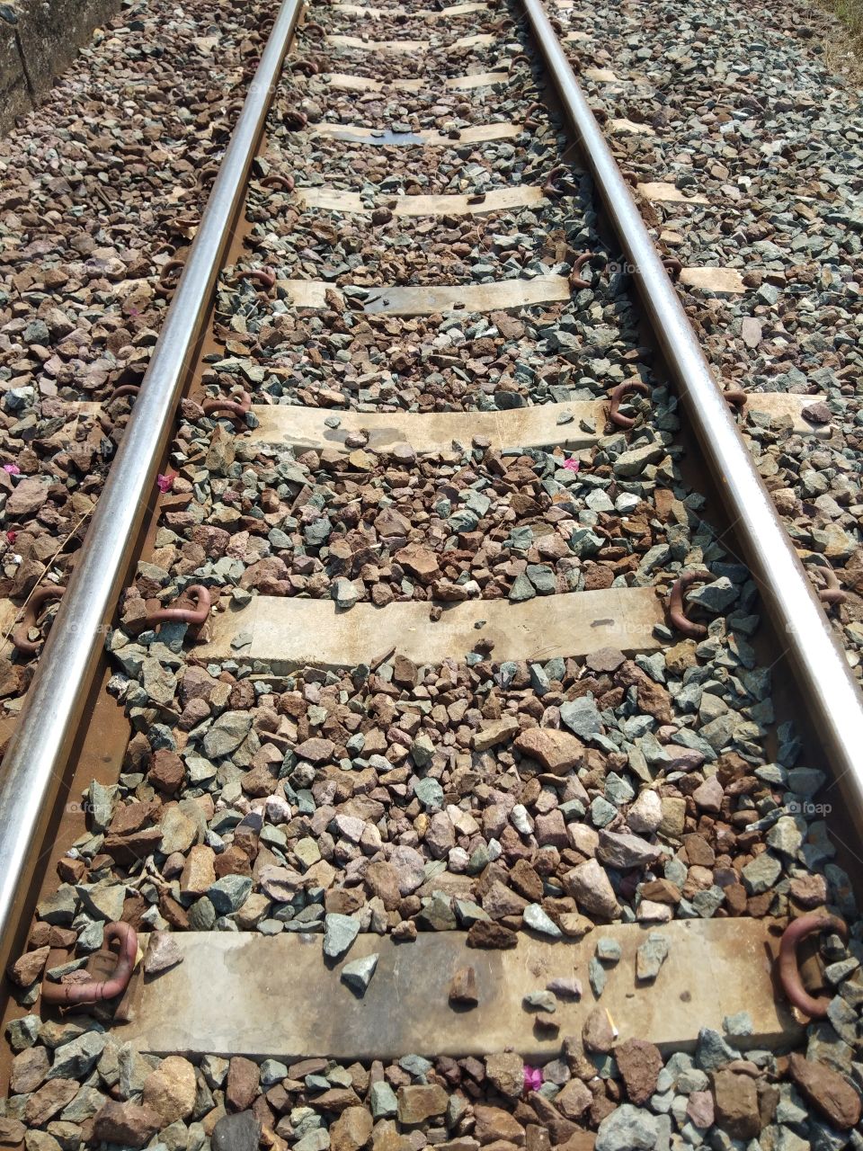 Straight lines parallel of the metal railway on the gravel floor.