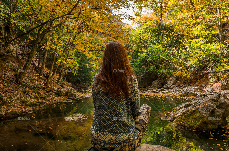 girl is meditating on the shore of a forest lake