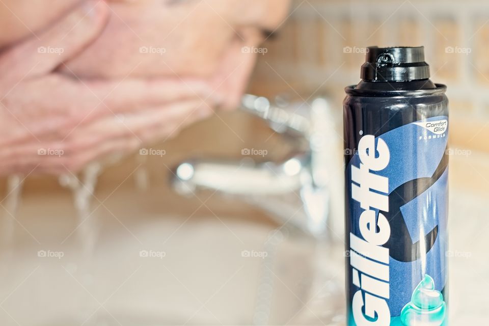 A man wet his face before shaving