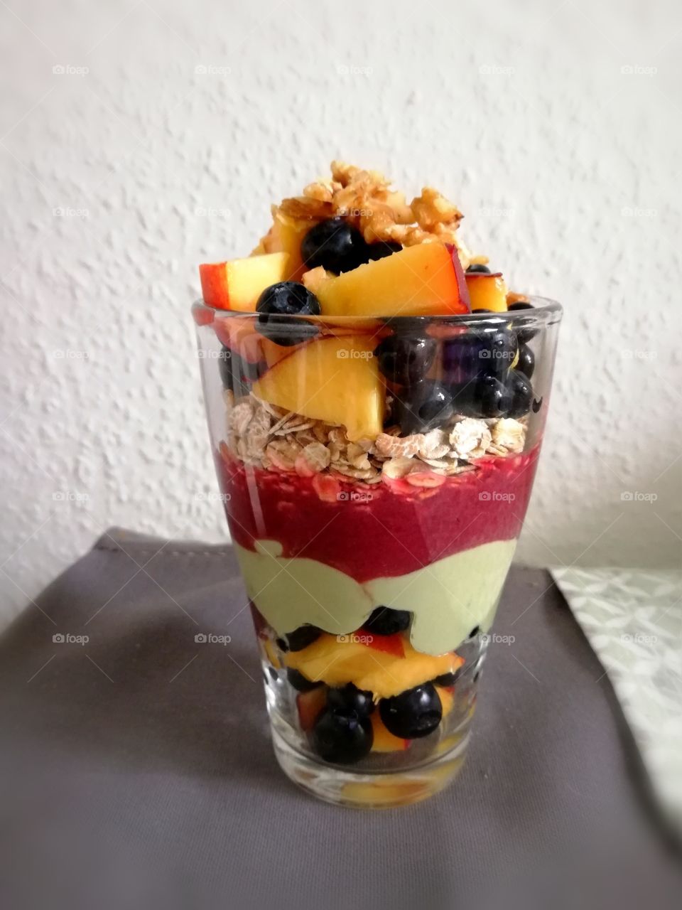 Glass with oats, fruit and matcha yogurt for breakfast