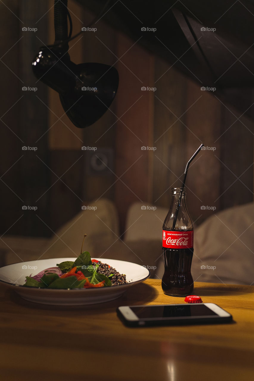 delicious afternoon tea, diet salad, coca-cola.  the phone is on the table next to it.  beautiful advertisement for coca cola.  photo content