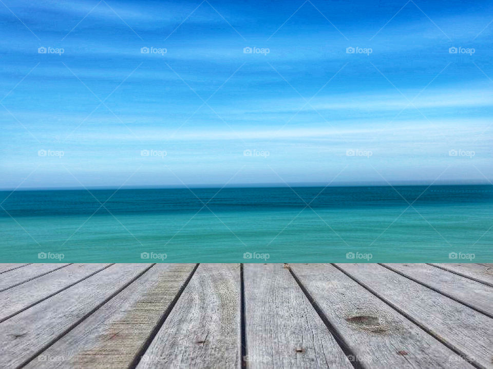 Empty top of wooden table and view of tropical beach for product display. 
