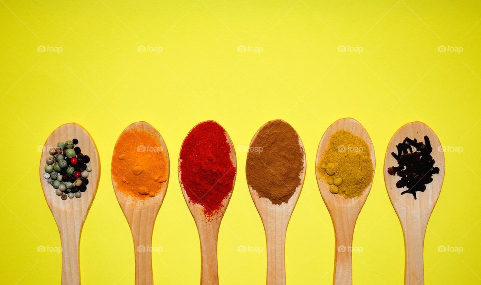 colored spices on yellow background