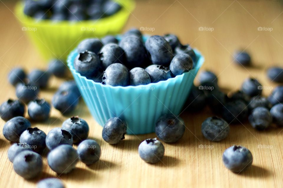 Fruits! - Blueberries In blue- and lime green-colored silicone baking cups on bamboo surface