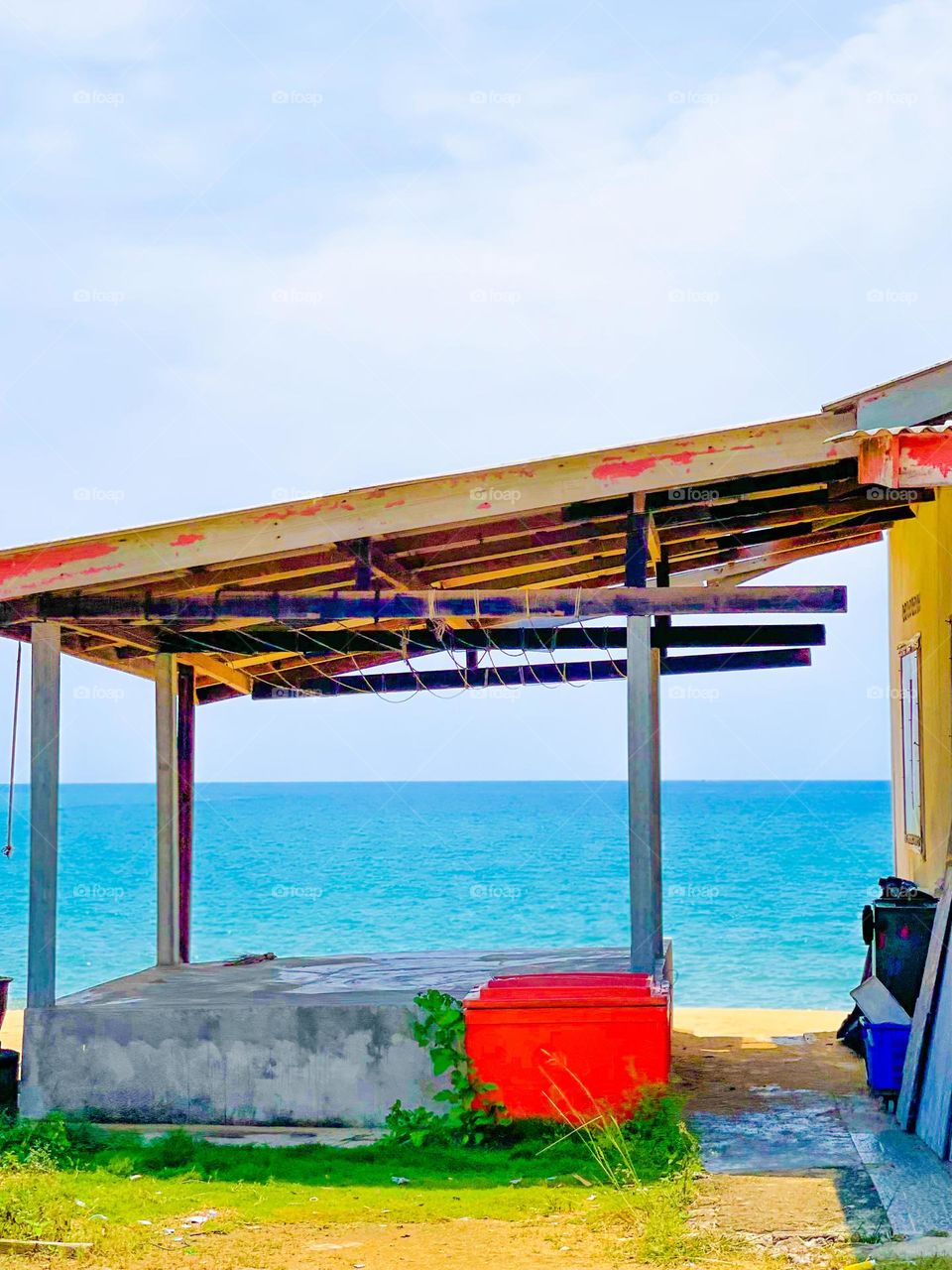 Fisherman hut with some fishing box and some equipments on the side with the sea view as background 