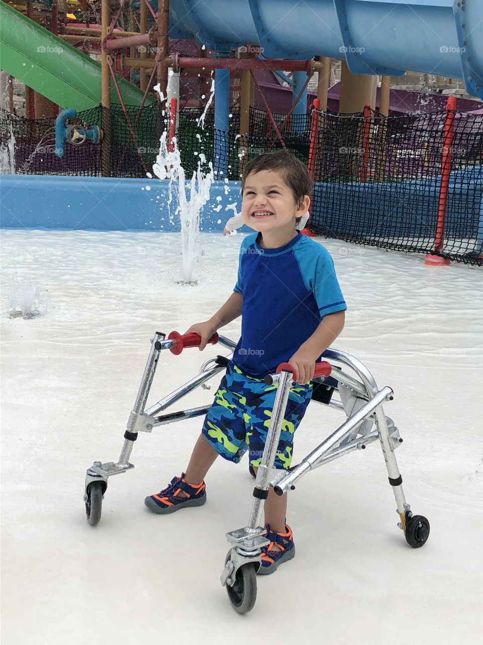 Toddler with special needs playing at waterpark