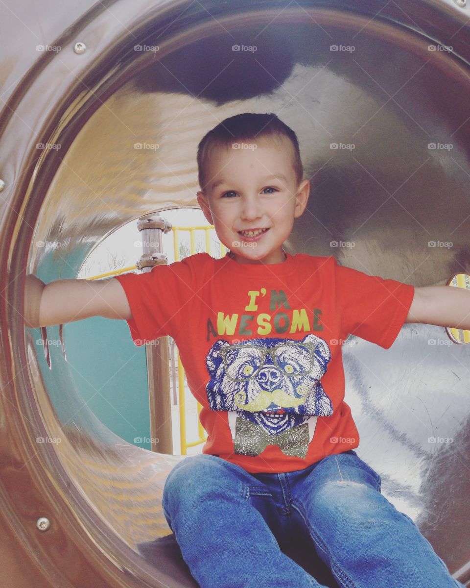 Boy sitting in toy tunnel