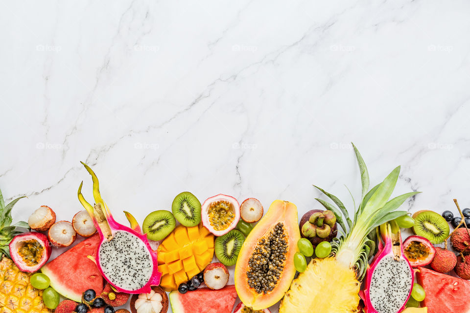 Fresh exotic fruits lying on marble background 