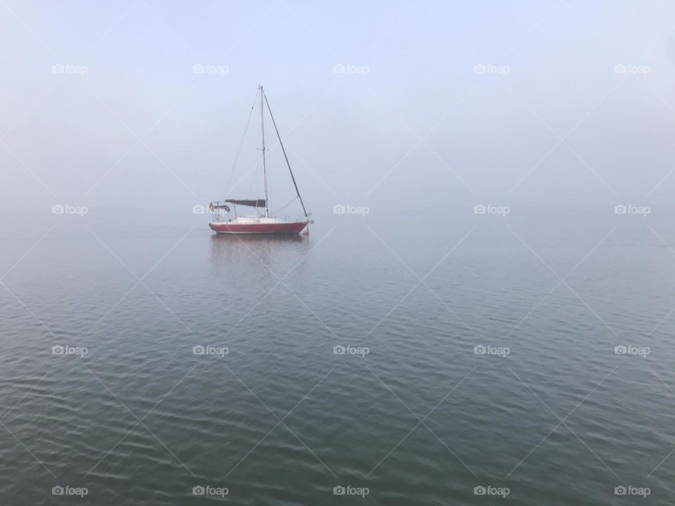 red sailboat on a foggy day