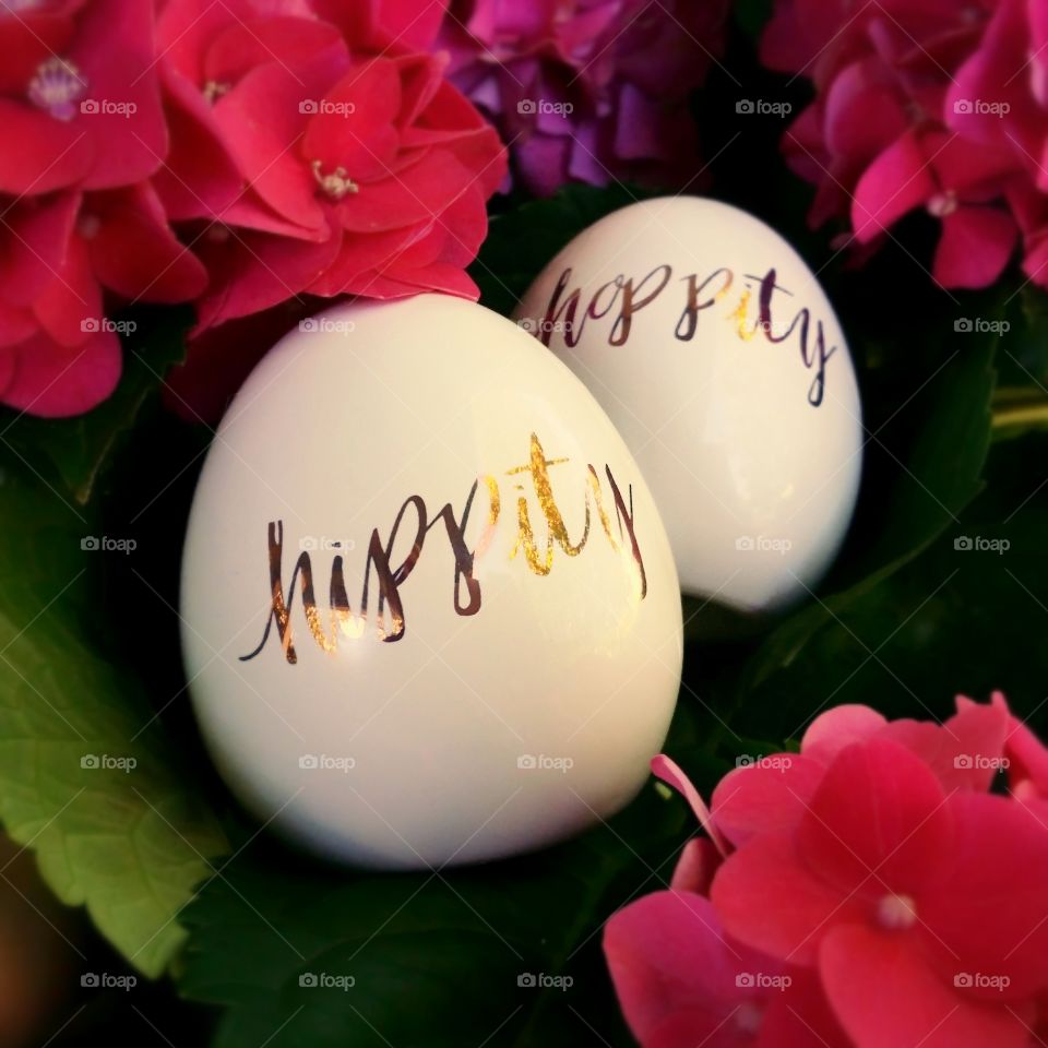 Eastern eggs with hippity hoppity written on them in the middle of an hydrangea flower
