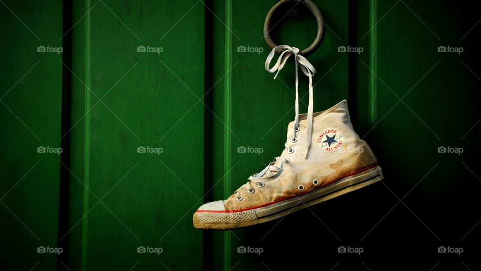 Dirty Lonely white chuck Taylor all star converse hanging by shoe string 