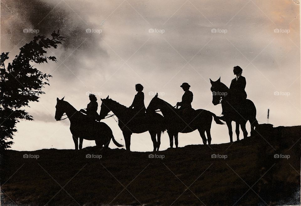 Profile of Horses and Riders at Sunset on Ridge