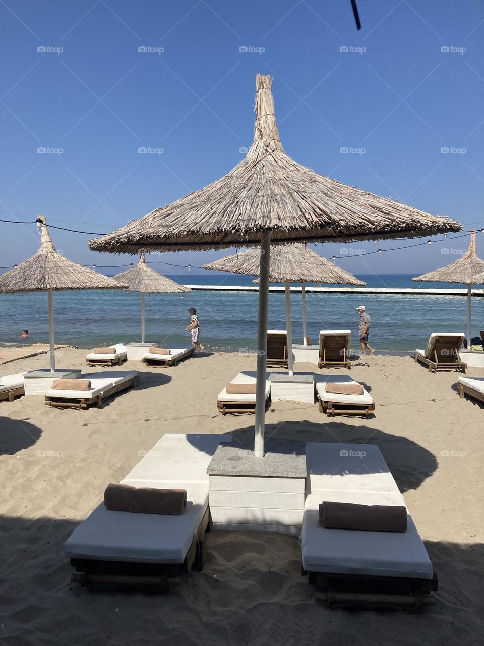 Beach time on holidays. Blue sky and tall palm trees. Sunsets and sunny days. Summertime in Kusadasi. Vacation travel in Turkey . Summer view. Sunny day during vacation 