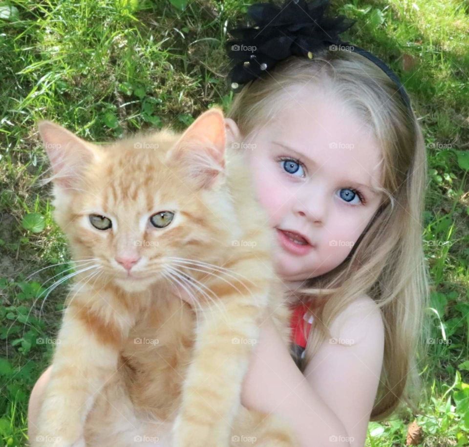 Beautiful baby girl showing her kitten.