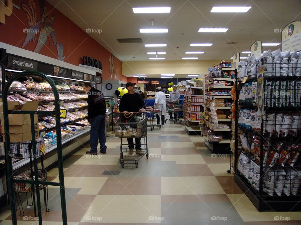 Men in grocery store shopping, with carriages
