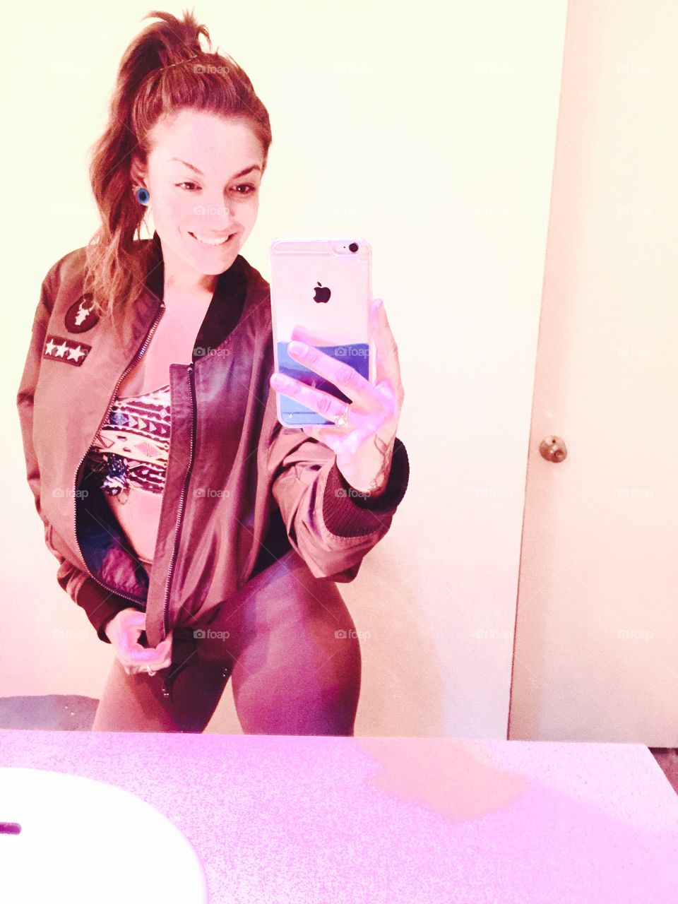 Reflection of a smiling woman taking selfie in mirror