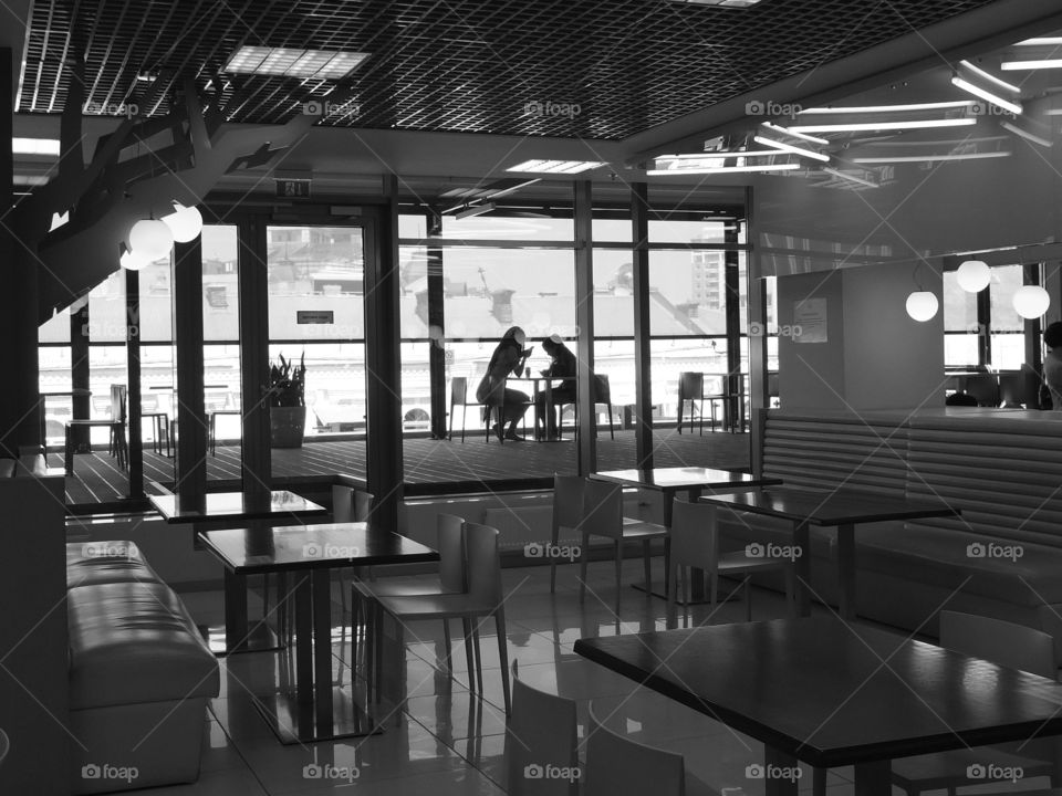 Silhouette. Conversation. Silhouettes of talking people. A cafe. BW.