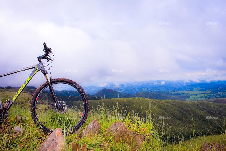 A bicycle alone with the beautiful view of nature in the background.