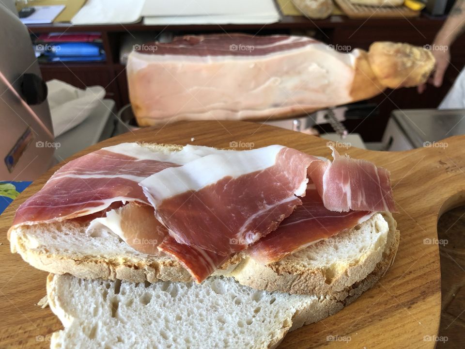 Fresh oven backed bread with hand cuttet italian ham in the butcher’s store