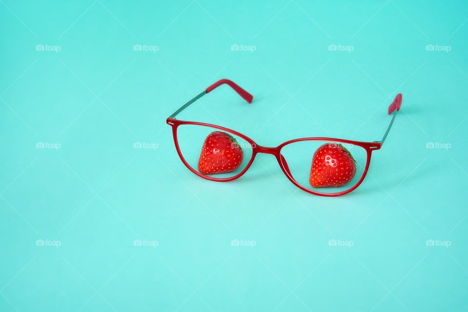 Red  eyeglass frame on a turquoise background