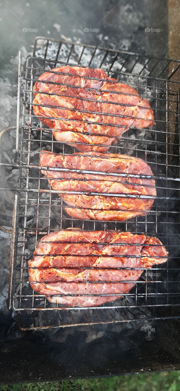 Cooking pork steak on the grill.