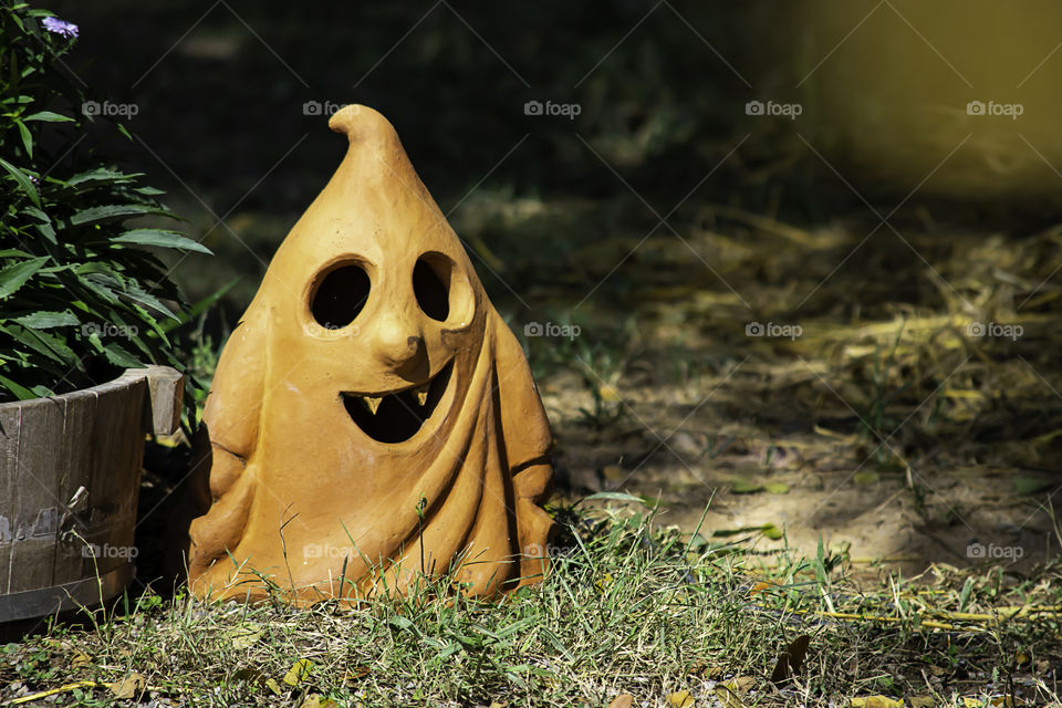 Halloween Brown clay doll shape ghost in garden.