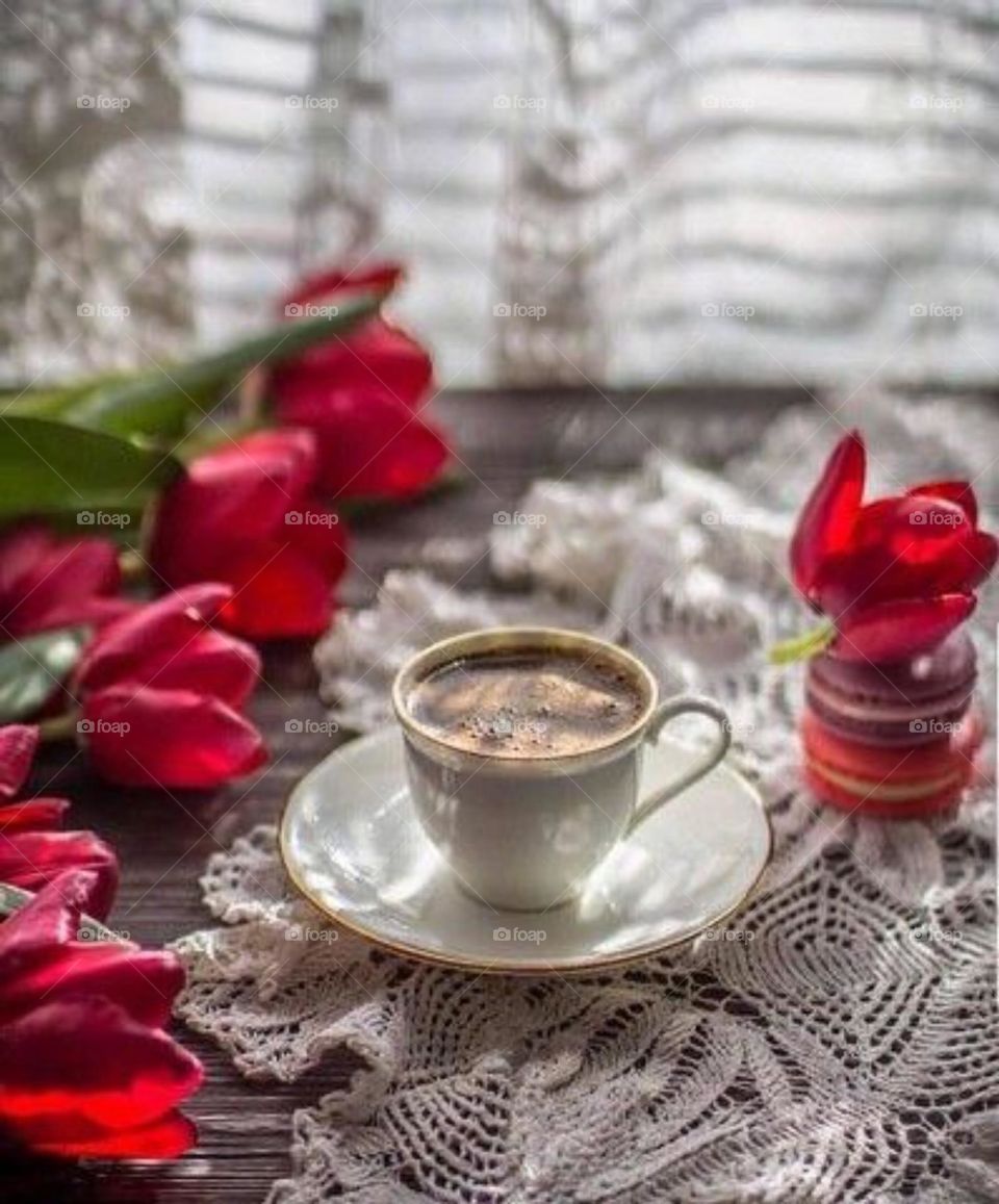 Serve a cup of coffee with flowers and orange slices