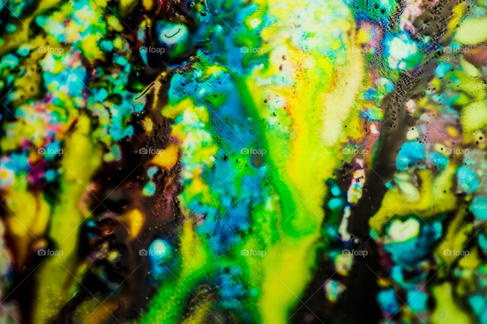 The ink to refill the printer cartridge was spilled onto the white washbasin and the paints blended into abstract drips and patterns.