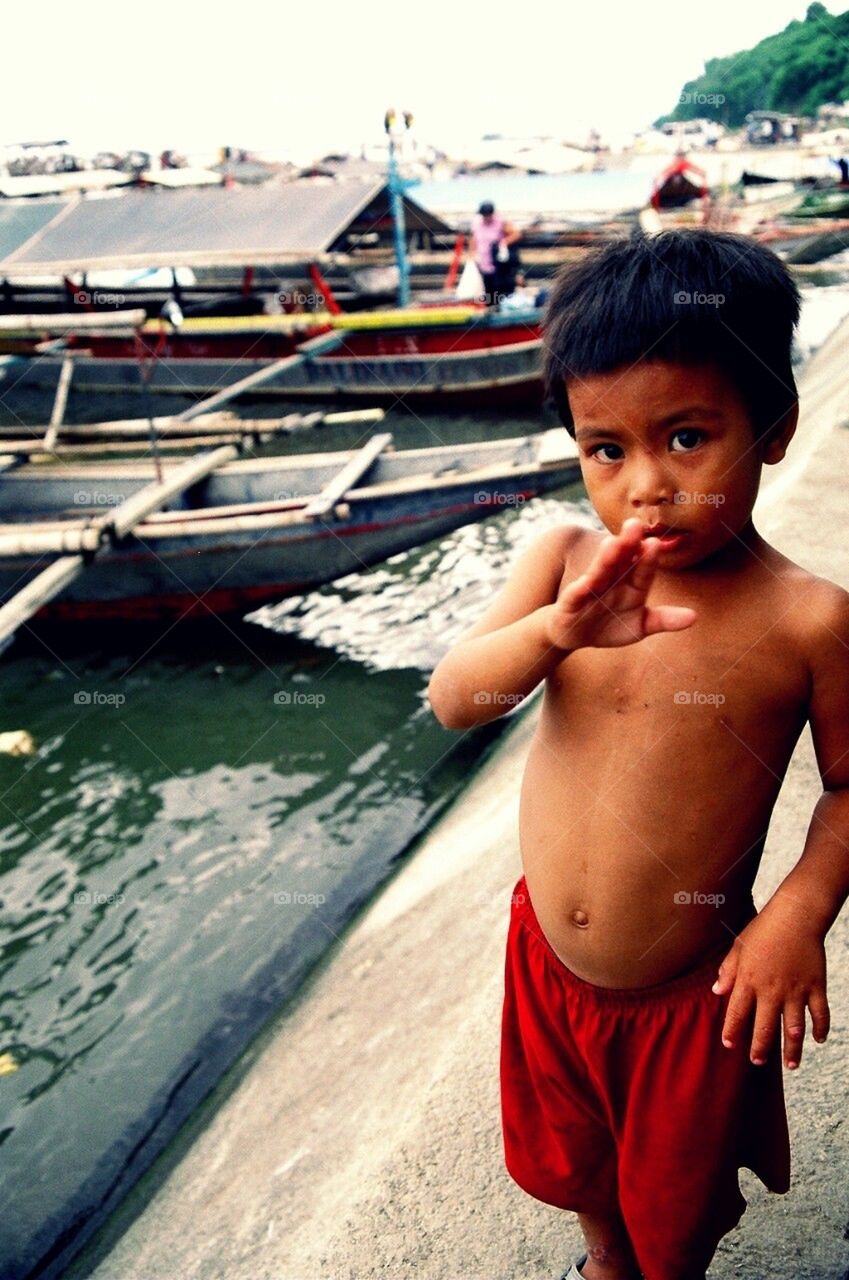 Little asian boy by a fish port