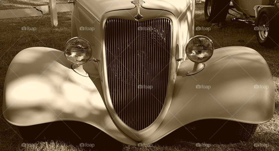 The front view of a vintage car at a car show. Uncertain or the make or model but the color was a matte grey.